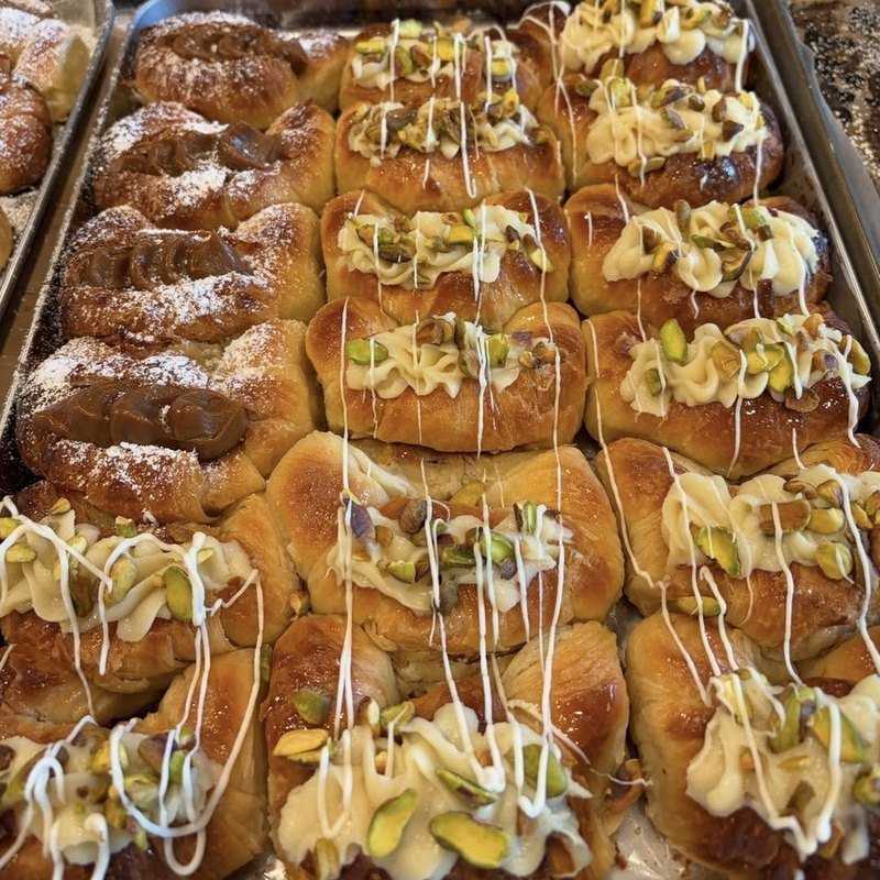 Medialunas filled with pistachio cream and finished with a white chocolate drizzle, baked in Richmond, VA